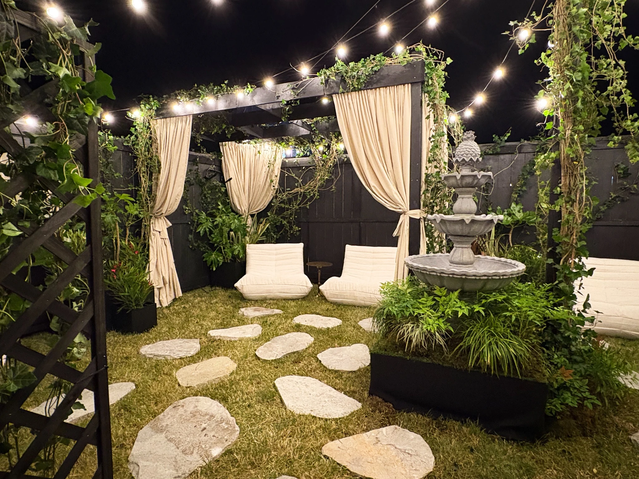 The intimate Suprema garden installation with curtains, planting and warm string lights