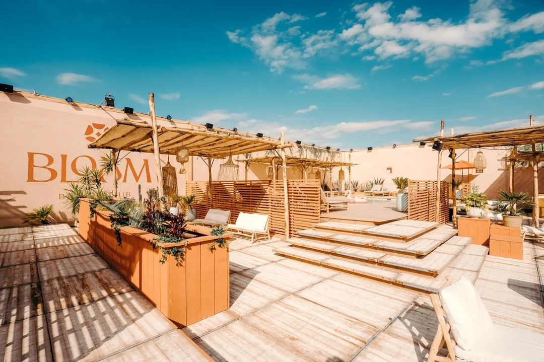 The sunlit timber terraces and planting at Bloom Beach Club